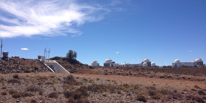 The photo shows the South African Astronomical Observatory (SAAO) with its numerous telescopes and SAGOS.