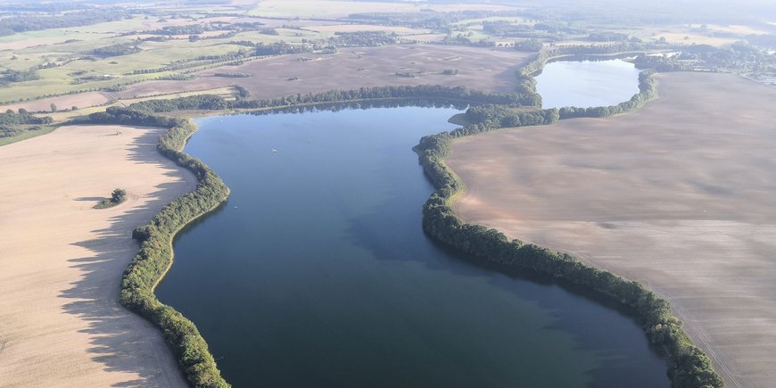 Aerial view of the elongated lake in the flat land.