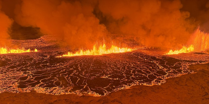 Vulkanausbruch aus der Nähe: eine Art "See" aus flüssiger Lava, darin Feuer und Rauchschwaden, alles in oranges Licht getaucht