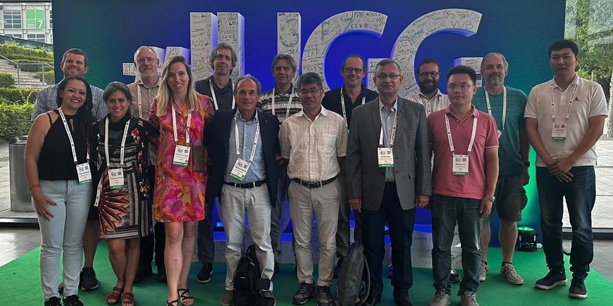 the 15 members of the IHFC in front of the IUGG logo, 3 women and 12 men
