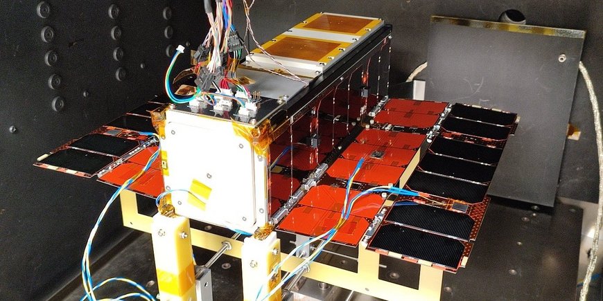 Kleinsatellit wartet auf seinen Einsatz in der Thermo-Vakuum-Kammer, rechteckig, verkabelt, mit kleinen Solarpanelen