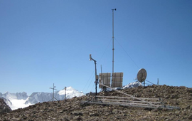 Station in Zentralasien, im Hintergrund schneebedeckte Berge