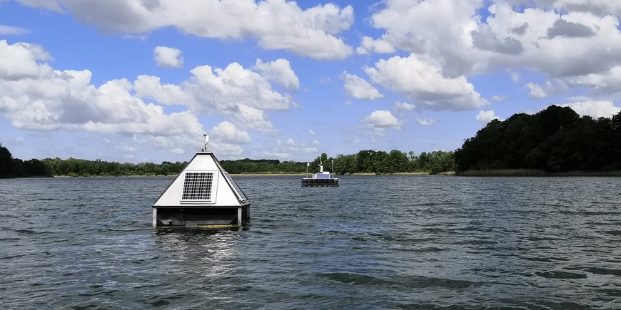 Auf einem See schwimmen pyramidenförmige Meessgeräte.