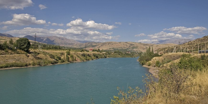 Chirchik Fluss. Landschaft mit Flussufer (grasbewachsen)