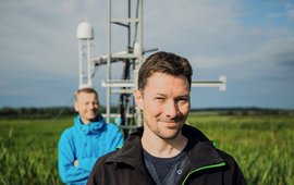 Torsten Sachs in front of a climate station on a field