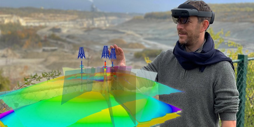 A person stands in the terrain with VR glasses on, in front of him a digital terrain model with which he is currently interacting.