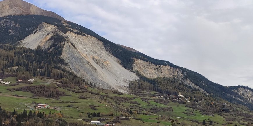A mountain with a boulder field, which is now sliding down, and the village below.