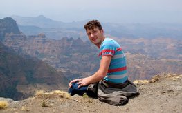 Michael Henehan sitzend vor einem Bergpanorama
