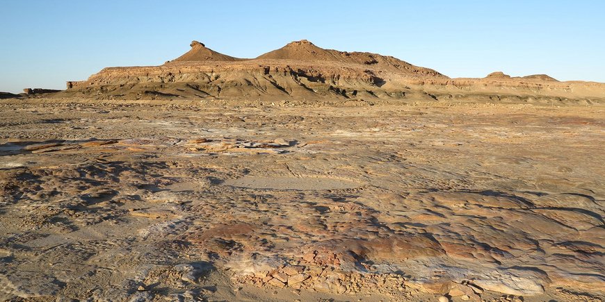 Ausgetrockneter Wüstensee auf der Arabischen Halbinsel mit Gebirgszug im Hintergrund