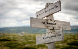 [Translate to English:] Ein Wegweiser vor einer verschwommenen Berglandschaft weist auf "Environmental" "Social" und "Governance".