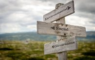 Ein Wegweiser vor einer verschwommenen Berglandschaft weist auf "Environmental" "Social" und "Governance".